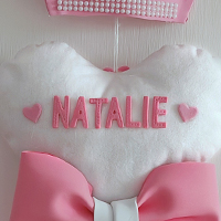 Particolare del nome "Natalie" in stampatello rosa, scritto in gomma EVA sul cuscinetto a forma di cuore