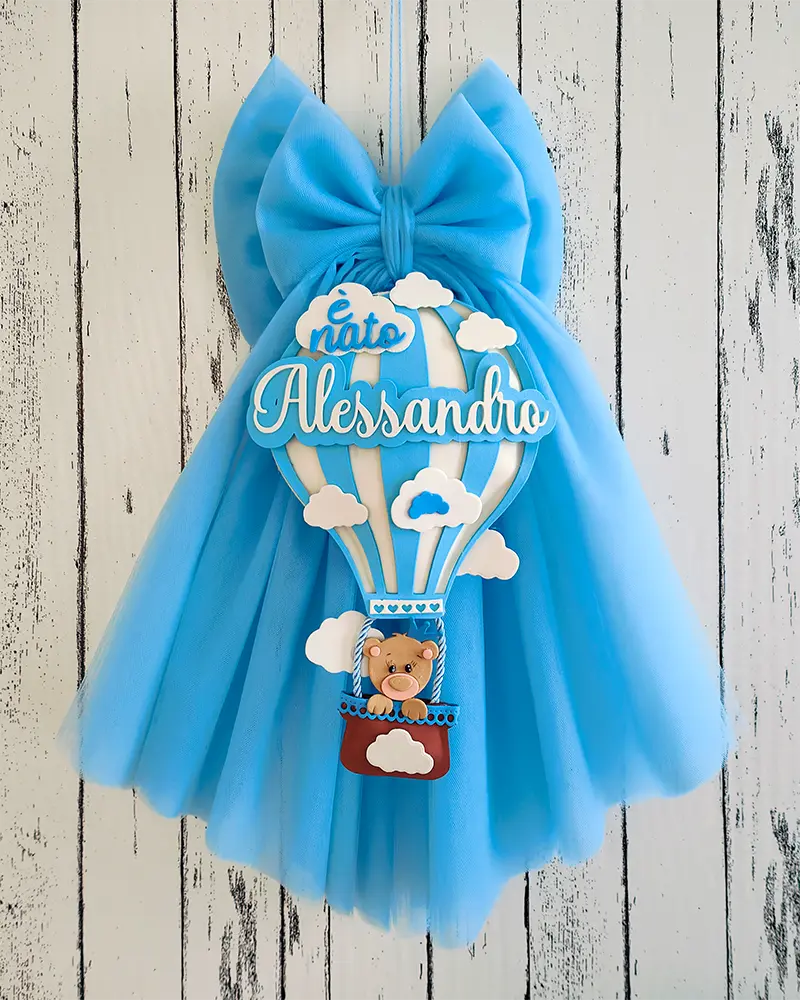 Una mongolfiera sopra un tulle celeste per il fiocco nascita di Alessandro.